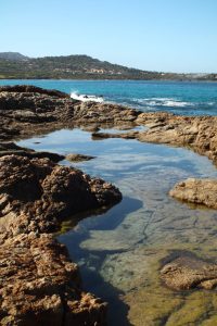 Explore the stunning rocky shoreline and crystal-clear waters at L'Île-Rousse, Corsica.
